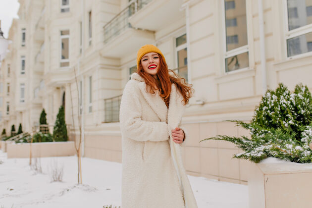 红发12月 身着长袍的极乐女人摆出姿势微笑着的姜姑娘的冬季肖像季节女人城市