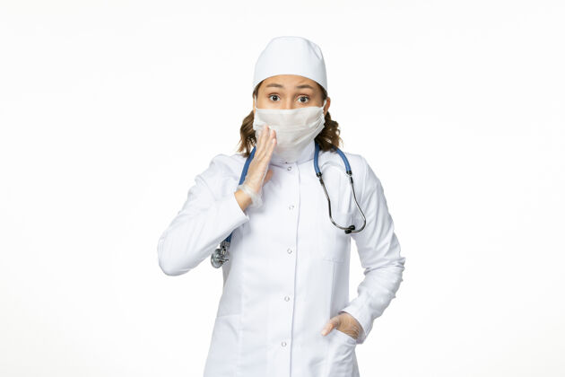 灭菌正面图年轻女医生戴着无菌口罩和手套 白色办公桌上有冠状病毒冠状病毒医生手套
