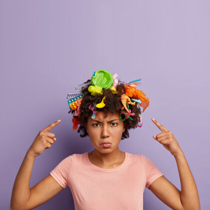 回收不满意的愤怒的女人在她的头发上摆垃圾生产指向女孩