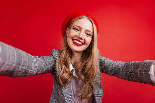 模特快乐的法国长发女孩自拍一个戴贝雷帽的金发美女 被隔离在红墙上女孩夹克幸福