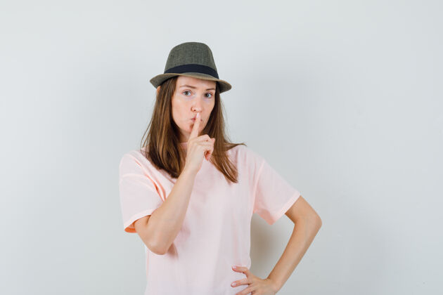 沉默年轻女性穿着粉色t恤 戴着帽子 表情谨慎 展现出沉默的姿态微笑黑发快乐