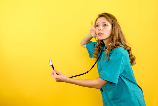 女医生前视图浅黄色空间上带听诊器的女医生设备正面医疗器械