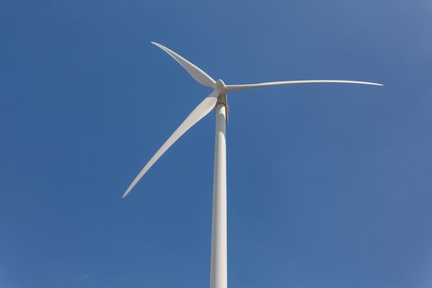 环境白天阳光和蓝天下风车的低角度拍摄涡轮机风车替代