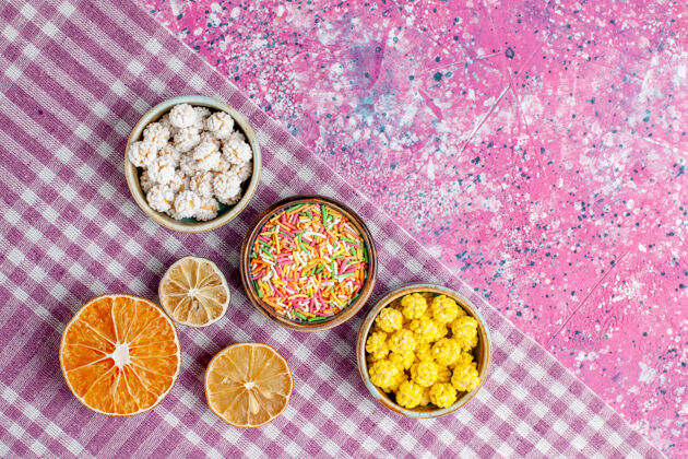 美味顶视图甜美的糖果五颜六色的知己在粉红色的书桌上糖果晚餐自封