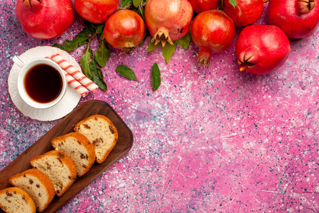 醇香在粉红色的桌子上 可以俯瞰新鲜的红石榴 切片蛋糕和一杯茶食品切片饮食
