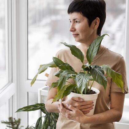 蔬菜手持花盆的女人的正视图种植植物种植