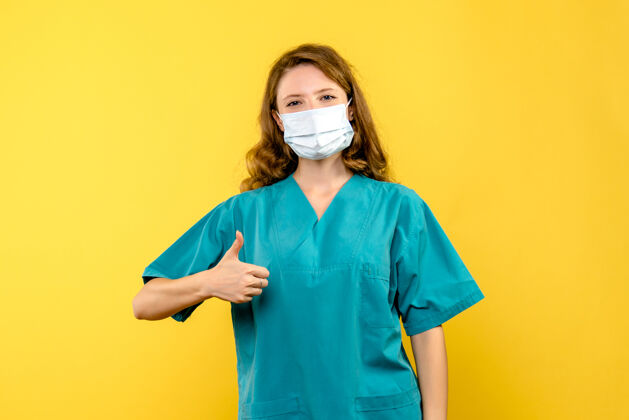 蓝色黄色空间里戴着面具的年轻女医生成人专业衬衫