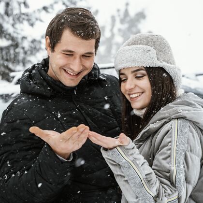 夫妇斯迈利夫妇在公路旅行中享受降雪的正面视图广场户外女性