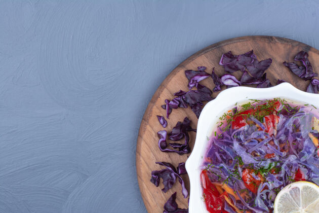 质量木板上的紫白菜辣椒汤健康菜单盘子