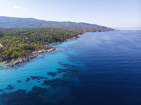 海滩爱琴海沿岸有蓝色透明的海水 周围绿意盎然 从无人机上俯瞰 希腊海景欧罗巴沙