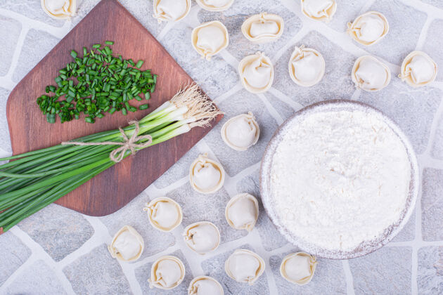 盘子高加索人在木板上用大葱做钦卡利面团健康新鲜面粉