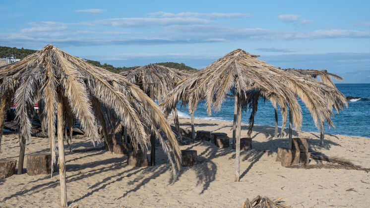 码头希腊的爱琴海海滩 用棕榈枝做成的雨伞海浪土耳其地中海
