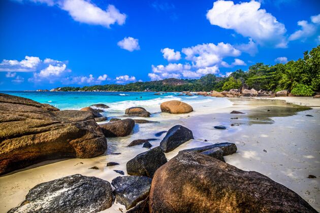 自然在塞舌尔的普拉斯林 海滩上的岩石被绿色植物和阳光下的大海包围海景海洋沙滩