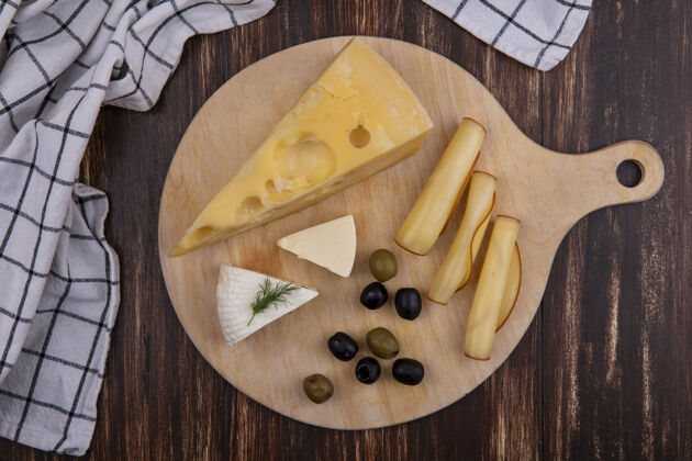 毛巾顶视图奶酪品种与橄榄上的立场与木纹毛巾背景架子木头奶酪