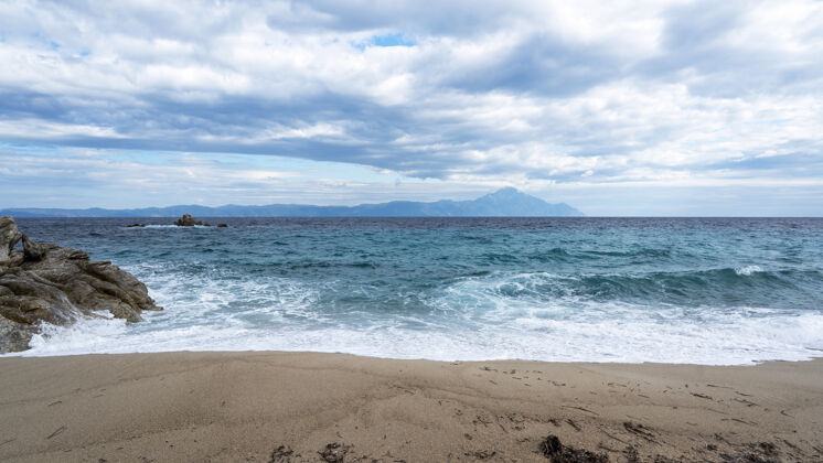 海景一个有岩石和爱琴海蓝色波浪的海滩 陆地和山脉海湾镁砂度假村
