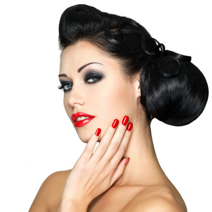 黑发美丽的时尚女性 红唇 指甲和创意发型-隔离在白墙上优雅指甲女人发型