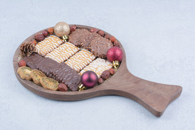 玫瑰果各种饼干 干果和圣诞球放在木板上甜点巧克力甜点
