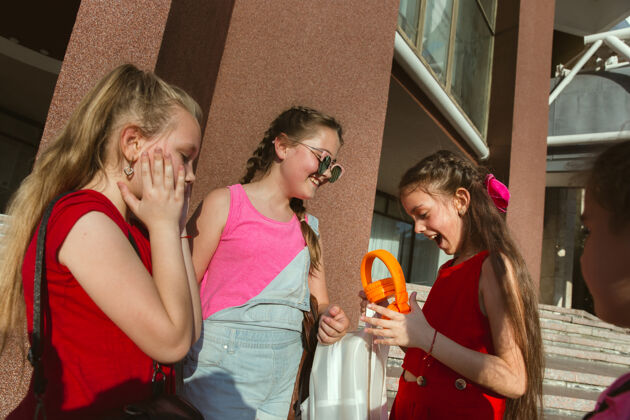 小在阳光明媚的夏日里 快乐的孩子们在城市的街道上玩耍一群快乐的孩子或青少年在一起玩耍友谊 童年 夏天 假期的概念少年聚在一起积极