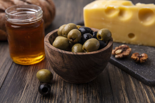 马斯丹正面图蜂蜜放在一个罐子里 马斯丹奶酪放在架子上 橄榄放在桌子上架子视野奶酪