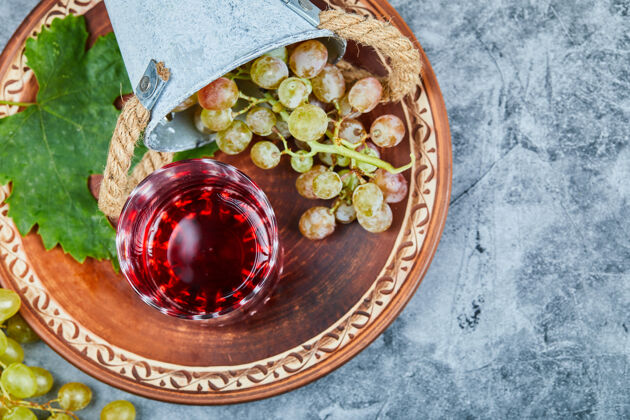 季节桌上有绿葡萄和一杯红酒素食膳食蔬菜