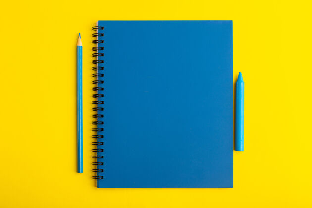 铅笔正面图打开黄色书桌上的蓝色铅笔抄写本笔记打开办公室
