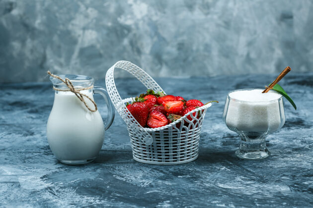 叶子一篮草莓 一壶牛奶 一杯酸奶 深蓝色大理石背景 特写成熟草莓食物