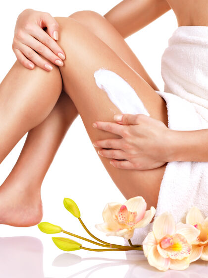 健康女人用一个美丽的身体在她的腿上涂一层白霜坐姿毛巾花