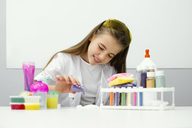 科学年轻的女科学家正在用黏液和颜色做实验的前视图孩子实验室外套粘液