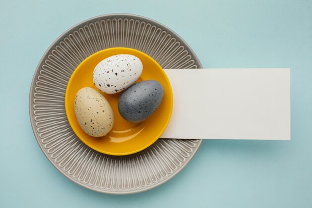 节日彩色复活节彩蛋的顶视图在多个盘子上用纸盘子平铺纪念