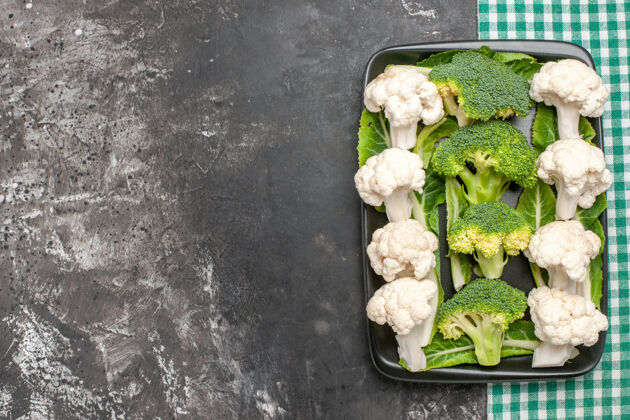 花椰菜顶视图生西兰花和花椰菜在黑色矩形板上绿色和白色方格餐巾在黑暗的表面与复制空间蔬菜生的餐巾