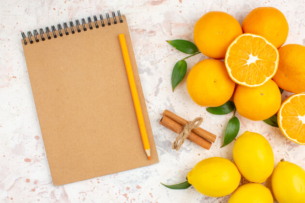 柠檬顶视图新鲜柑橘柠檬肉桂笔记本铅笔明亮的表面铅笔柠檬多汁