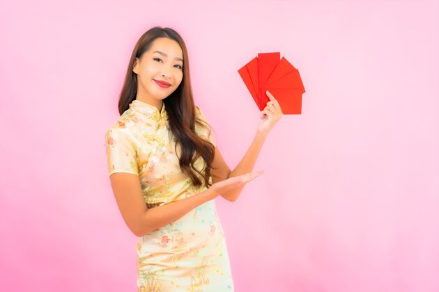 中国人在粉红色的墙上画一幅美丽的亚洲年轻女子拿着红包节日人微笑