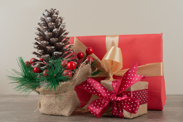 盒子松果装饰冬青浆果和礼品袋大理石桌上冬青浆果装饰松