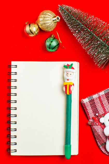 书写工具垂直视图螺旋笔记本与笔圣诞树装饰配件上的红色背景书签视图图形