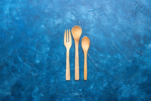 银器顶视图木制叉子勺子刀上蓝色的桌子与自由的地方晚餐地方木勺