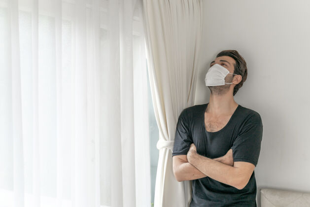 男性在检疫室戴口罩以防因冠状病毒冠状病毒-19引起头痛和咳嗽白天传播咳嗽