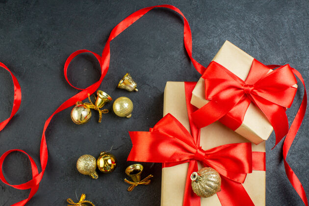 礼品盒黑色背景上带有红丝带和装饰配件的礼盒顶视图圣诞项链珠宝