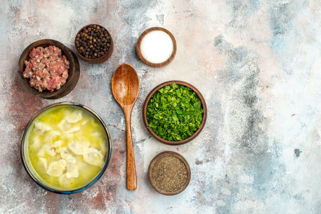 晚餐俯视图杜什巴拉碗不同香料绿色肉木勺上裸体表面免费放置食物照片胡椒碗绿色