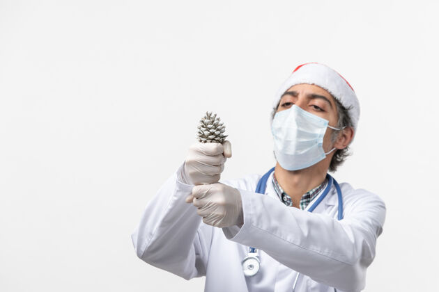 实验室外套正面图：男医生拿着雪糕筒在白色墙壁上-圣诞健康病毒服装病毒冠状病毒