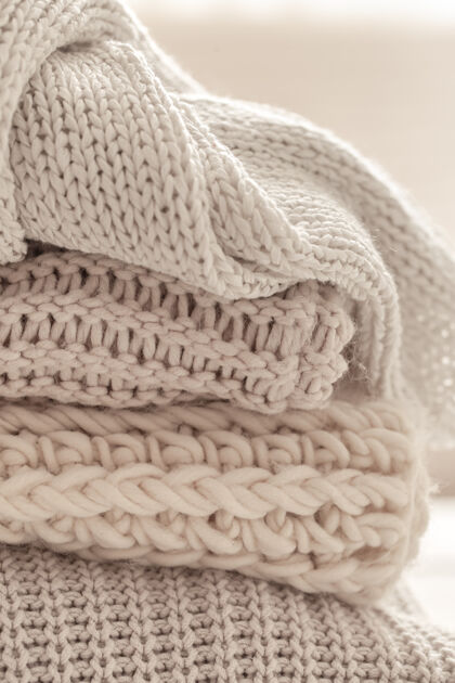 针织在模糊的白色背景上有一堆温暖的针织物围巾冬季针织品