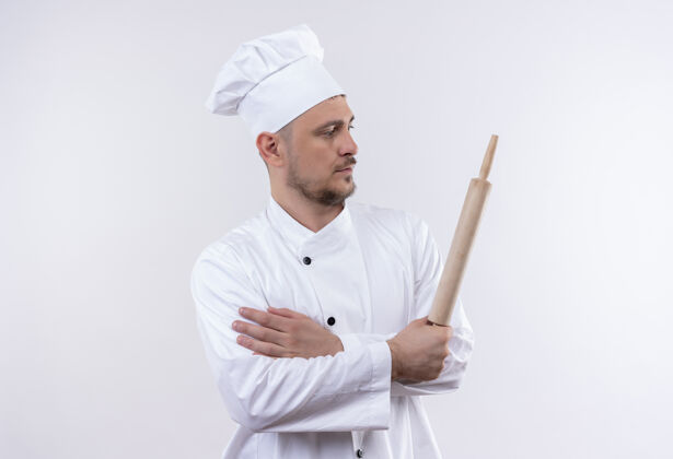 厨师年轻帅气的厨师穿着厨师制服拿着擀面杖望着旁边孤立的白色空间厨师制服侧
