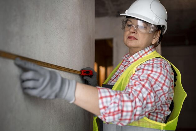 职业带头盔和卷尺的女建筑工人头盔技能就业
