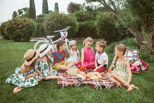 变异儿童时尚概念一群十几岁的男孩和女孩坐在公园的绿草地上青年后代公园