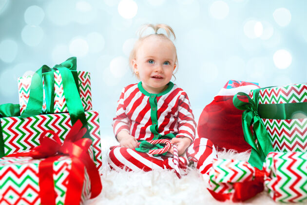成长可爱的女婴 1岁 戴着圣诞帽 带着圣诞装饰 坐在地上玩圣诞球有趣庆祝抱着