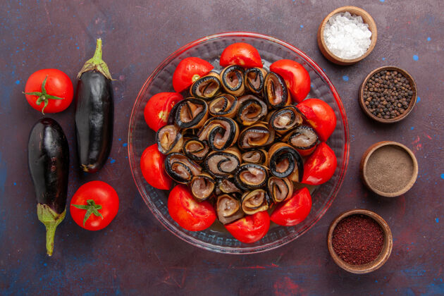 茄子俯视图蔬菜餐切片和卷西红柿与茄子和调味品在黑暗的背景美味烹饪香料
