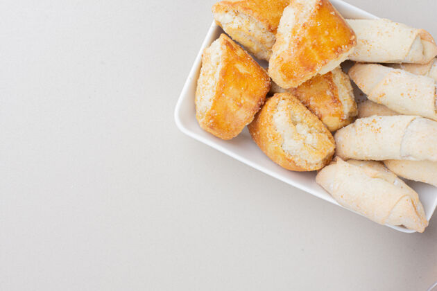 甜点各种传统饼干的盘子放在白色的表面上美味视图甜点