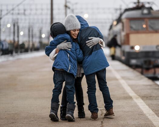 旅行者全镜头女人在户外拥抱孩子火车站旅游者旅行
