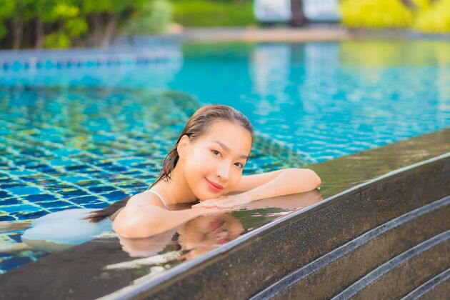 阳光肖像美丽的亚洲年轻女子放松微笑休闲围绕室外游泳池近海乐趣旅游活动