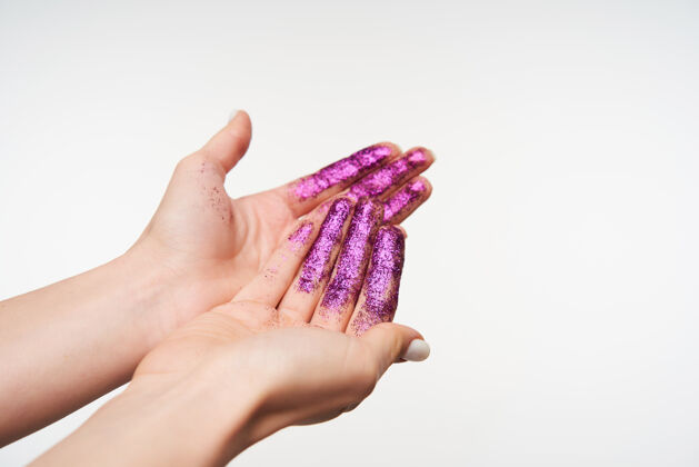 女性画中的年轻女士的手的特写镜头 紫色的闪光 显示手掌向上 同时在白色上摆姿势肢体语言和手的概念手臂升起身体