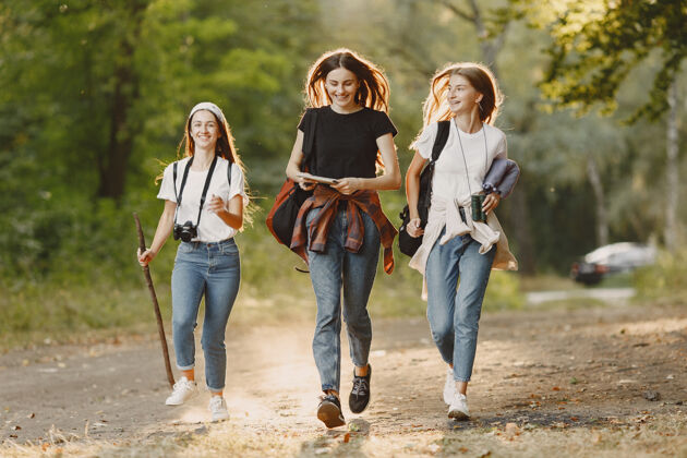 活动冒险 旅游 远足和人的概念三个女孩在森林里牛仔裤自然运动